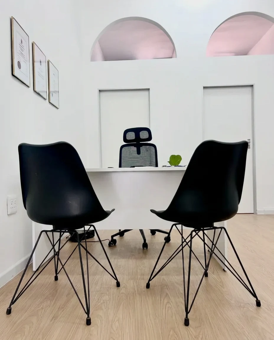 Consulting room with a desk, two patient chairs and natural light